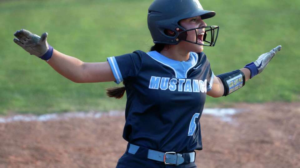 Kingwood's Leilani Garcia signals that Ava Jolley is safe at first in the third inning during Game 2 of the Region III-6A final high school softball series at Katy High School, Friday, May 24, 2024, in Katy. Jolley was ruled safe on the play.