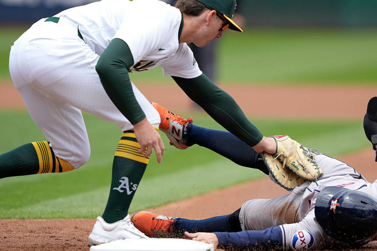 Jose Altuve #27 of the Houston Astros dives back into first base and is tagged out by Tyler Soderstrom #21 of the Oakland Athletics in the top of the first inning on May 25, 2024 at the Oakland Coliseum in Oakland, California. (Photo by Thearon W. Henderson/Getty Images)