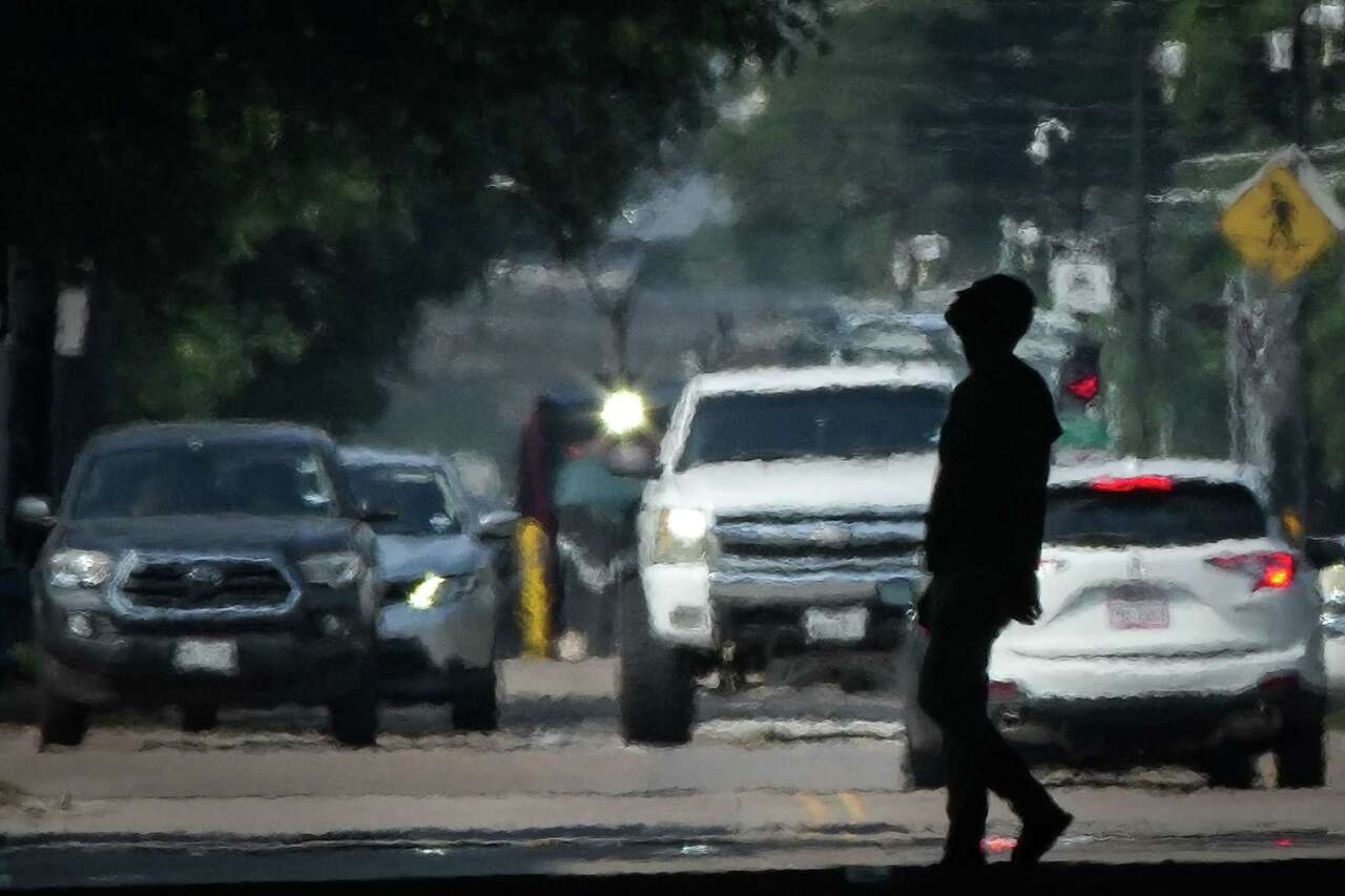 A person crosses Main Street in the afternoon heat Saturday, May 25, 2024, near downtown in Houston.