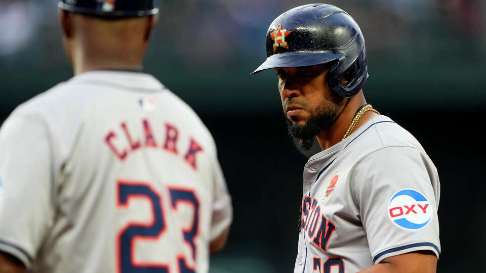 Houston Astros' José Abreu is greeted by first base coach Dave Clark after hitting an RBI single to score Jake Meyers against the Seattle Mariners during the fifth inning of a baseball game, Monday, May 27, 2024, in Seattle. (AP Photo/Lindsey Wasson)