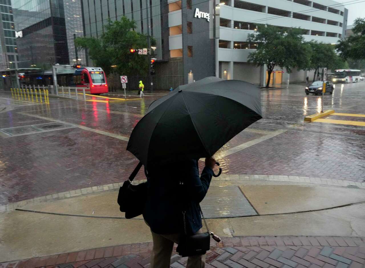 A person crosses Main Street at St. Joseph Parkway during the storm Tuesday, May 28, 2024 at in downtown Houston.