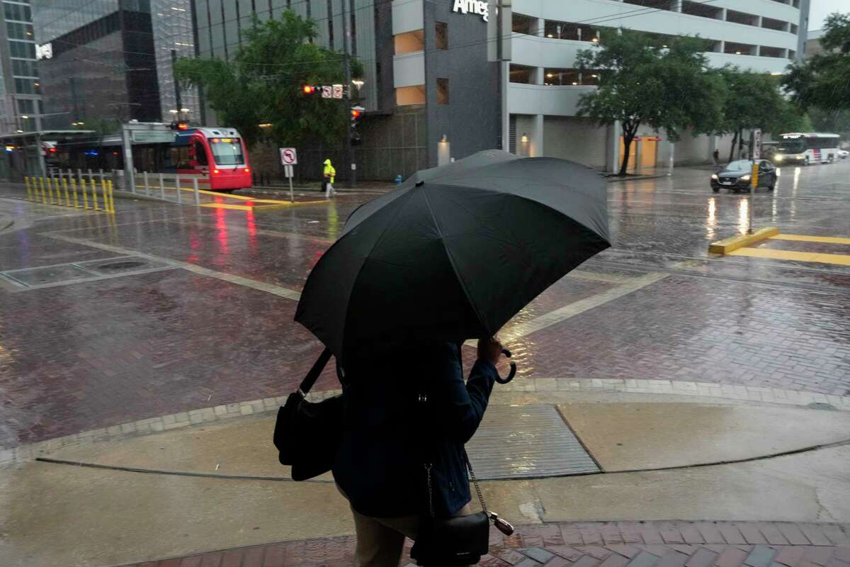 A person crosses Main Street at St. Joseph Parkway during the storm Tuesday, May 28, 2024 at in downtown Houston.