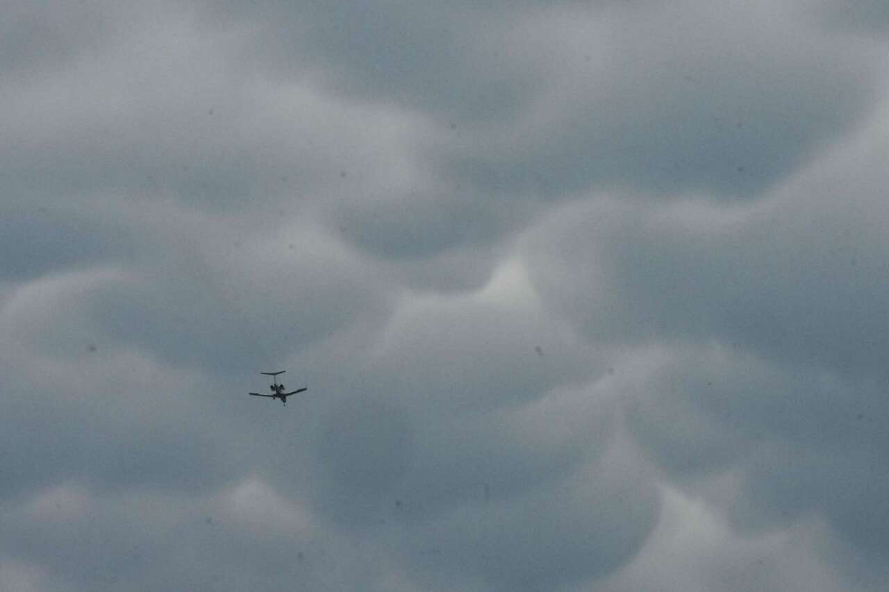 A plane flies under mammatus clouds after a storm moved through the area Tuesday, May 28, 2024, in the Third Ward neighborhood in Houston.