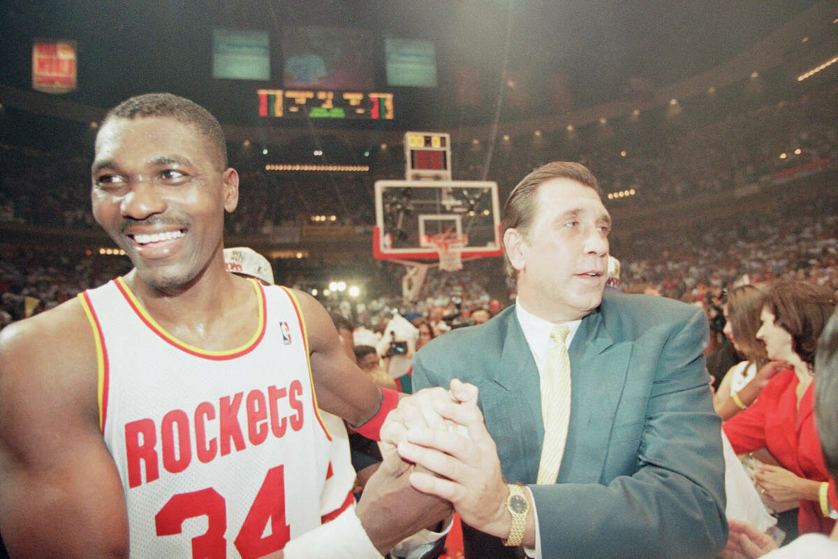 Houston Rockets center Hakeem Olajuwon, left, and Rockets coach Rudy Tomjanovich shake hands as they celebrate their second straight NBA championship, Wednesday, June 14, 1995, in Houston. The Rocket beat the Orlando Magic 113-101 in Game 4 of the NBA Finals to sweep the Magic 4-0. 