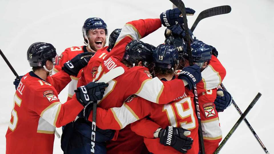 Florida Panthers center Sam Reinhart, far right, is mobbed by teammates after he scored during an overtime period of Game 4 during the Eastern Conference finals of the NHL hockey Stanley Cup playoffs to beat the New York Rangers, Tuesday, May 28, 2024, in Sunrise, Fla.