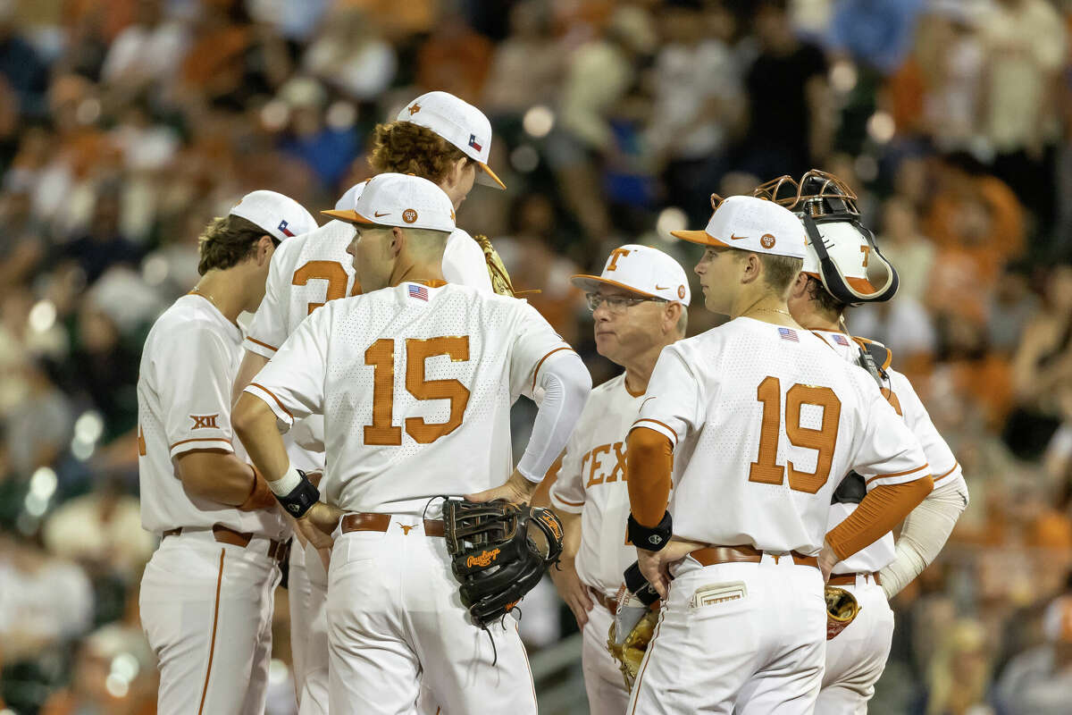 Texas Longhorn players stand on the mound during a pitcher switch during the Big 12 Conference baseball game between Texas Longhorns and Oklahoma Sooners on May 1, 2022, at UFCU Disch-Falk Field in Austin, TX. 