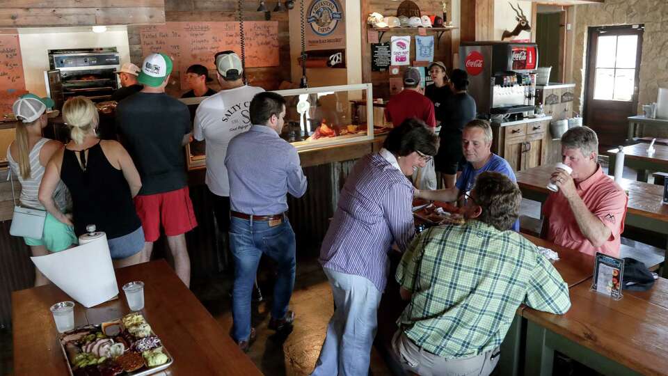 Lupe Valdez, center-right, Democratic candidate for governor of Texas, talks with Lloyd Walker, from clockwise, Shane Schlemeyer and Jay Davis, at Pinkerton's Barbecue, Friday, June 8, 2018, in Houston. During Hurricane Harvey, employees kept the restaurant open to feed residents and first responders.