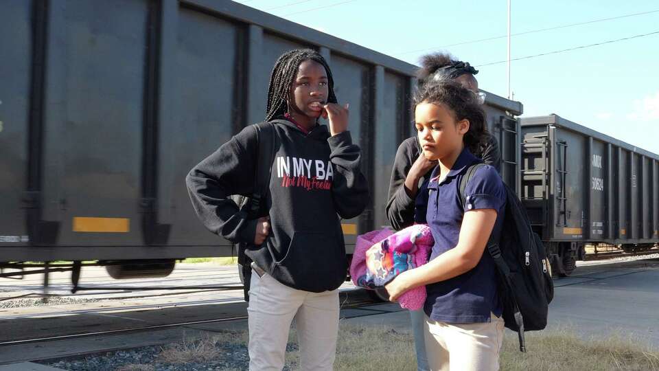 McReynolds Middle School students are blocked by a train as they walk home from school on October 22, 2022. The school is about 300 feet from a busy section of tracks close to the Union Pacific Englewood Yard in Houston’s Fifth Ward.