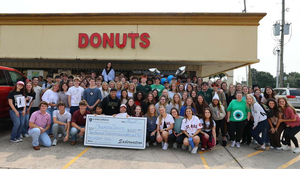 Concordia Lutheran High School seniors surprise Champion Donuts owners Leangheng Pin(Left) and Mala Sou(right) with check during senior prank.