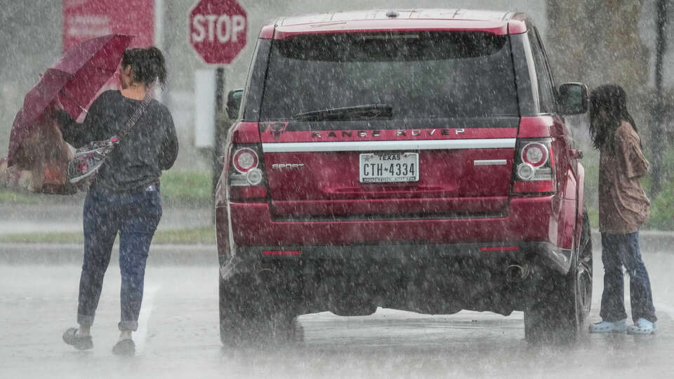 A woman and a girl get to their car during a heavy rain storm that swept through the Houston area on Tuesday in Spring.