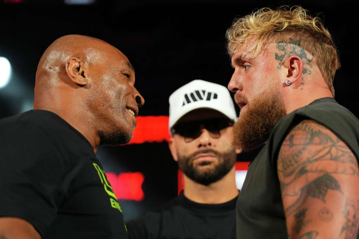 ARLINGTON, TEXAS - MAY 16: (L-R) Mike Tyson, Nakisa Bidarian and Jake Paul pose onstage during the Jake Paul vs. Mike Tyson Boxing match Arlington press conference at Texas Live! on May 16, 2024 in Arlington, Texas. (Photo by Cooper Neill/Getty Images for Netflix)