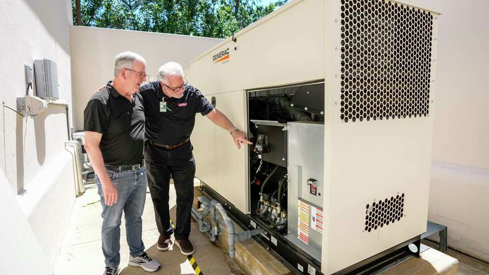 Homeowner Richard Holmes with his electrician, Rich Gillette of John Moore Services, explaining how the large in-home generator works at his home on Saturday, June 1, 2024, in Houston.