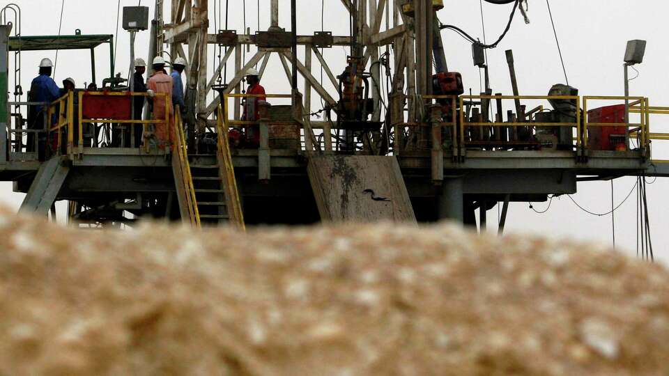 FILE - Oil workers stand on a new rig Tuesday, June 17, 2008, in the Sakhir, Bahrain, desert. Saudi Arabia and allied oil producing countries face a decision Sunday, June 2, 2024, on whether to extend production cuts set to expire next month — a move that could push oil prices higher as the summer travel season increases demand for fuel and as the U.S. presidential election contest heats up.