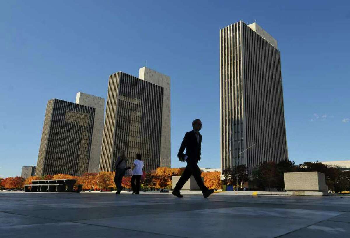 Gov. David Paterson says 898 public employees will be laid off this year in an effort to reduce the state work force. Pedestrians walk on the Empire State Plaza in Albany, NY on Thursday October 28, 2010. ( Philip Kamrass / Times Union )