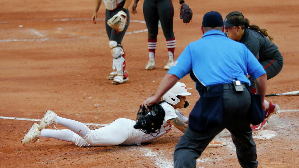 Alyssa Washington #11 of the Texas Longhorns scores the winning run at the plate against catcher Aly Kaneshiro #4 of the Stanford Cardinals in the seventh inning during the 2024 NCAA Women's College World Series at OGE Energy Field at Devon Park on June 3, 2024 in Oklahoma City, Oklahoma. Texas won 1-0 to advance to the Finals. (Photo by Brian Bahr/Getty Images)