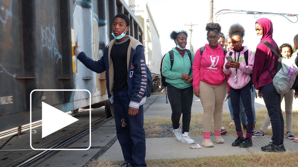 McReynolds Middle School students are blocked by a train as they walk home from school on October 22, 2022. The school is about 300 feet from a busy section of tracks close to the Union Pacific Englewood Yard in Houston's Fifth Ward.