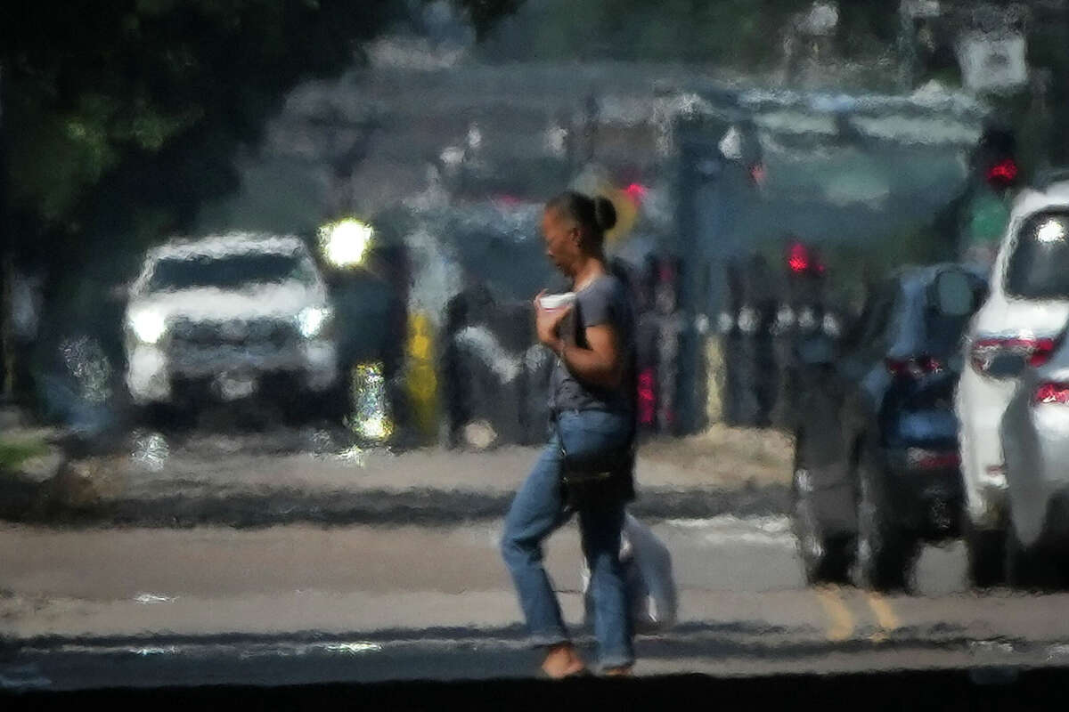 A person crosses Main Street in the afternoon heat Saturday near downtown in Houston. The city deals with not just extreme temperatures in the summer but also high levels of sticky humidity.