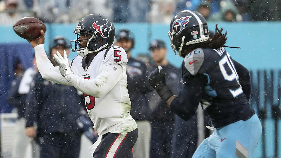 Houston Texans quarterback Tyrod Taylor (5) dumps off a pass as he is pressured by Tennessee Titans defensive end Denico Autry (96) during the second half of an NFL football game Sunday, Nov. 21, 2021, in Nashville.