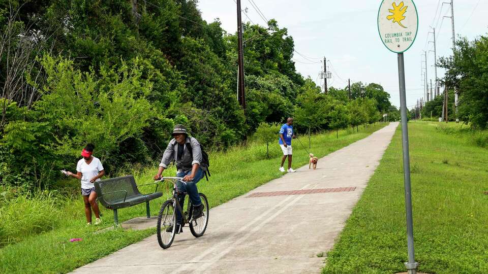 Sharon Evans-Brooks and her husband Juan Brooks walk along along the Columbia Tap Rail to Trail as a cyclist ride by on Wednesday, June 5, 2024 in Houston. They are among many residents who have been asking officials for basic security lighting and benches for the trail for many years. The historic 4-mile trail that runs through Third Ward was once part of a nearly 50-mile rail line built by enslaved Black men to transport sugar and cotton from Brazoria County plantations to Houston. It was one of the first rail lines to be constructed in Texas before the Civil War and later used to transport Black leased convicts to work the plantations.