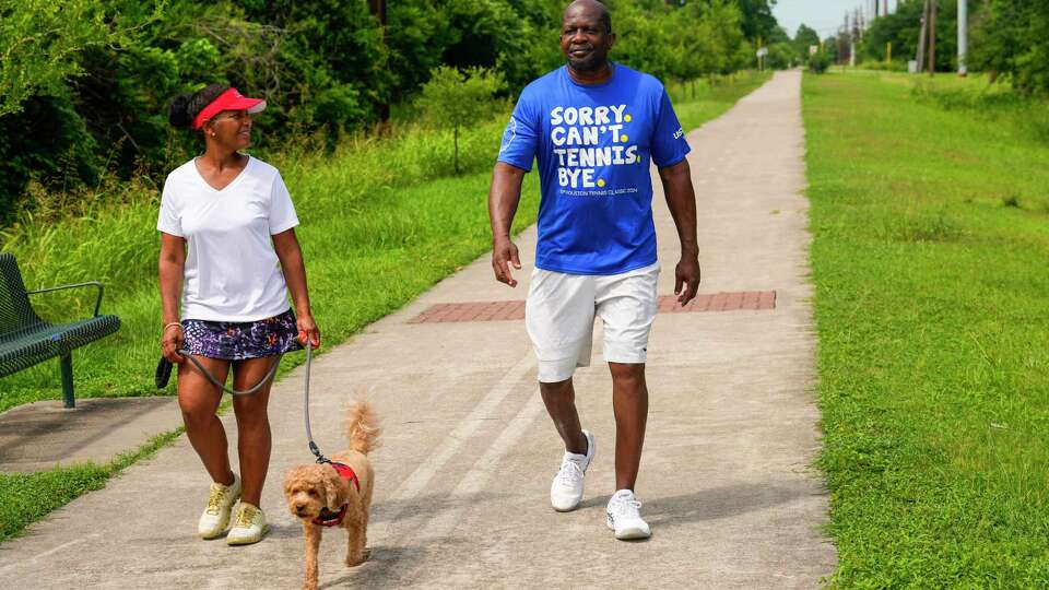 Sharon Evans-Brooks and her husband Juan Brooks walk along the Columbia Tap Rail to Trail with their dog, Tom Brady, on Wednesday, June 5, 2024 in Houston. They are among many residents who have been asking officials for basic security lighting and benches for the trail for many years. The historic 4-mile trail that runs through Third Ward was once part of a nearly 50-mile rail line built by enslaved Black men to transport sugar and cotton from Brazoria County plantations to Houston. It was one of the first rail lines to be constructed in Texas before the Civil War and later used to transport Black leased convicts to work the plantations.