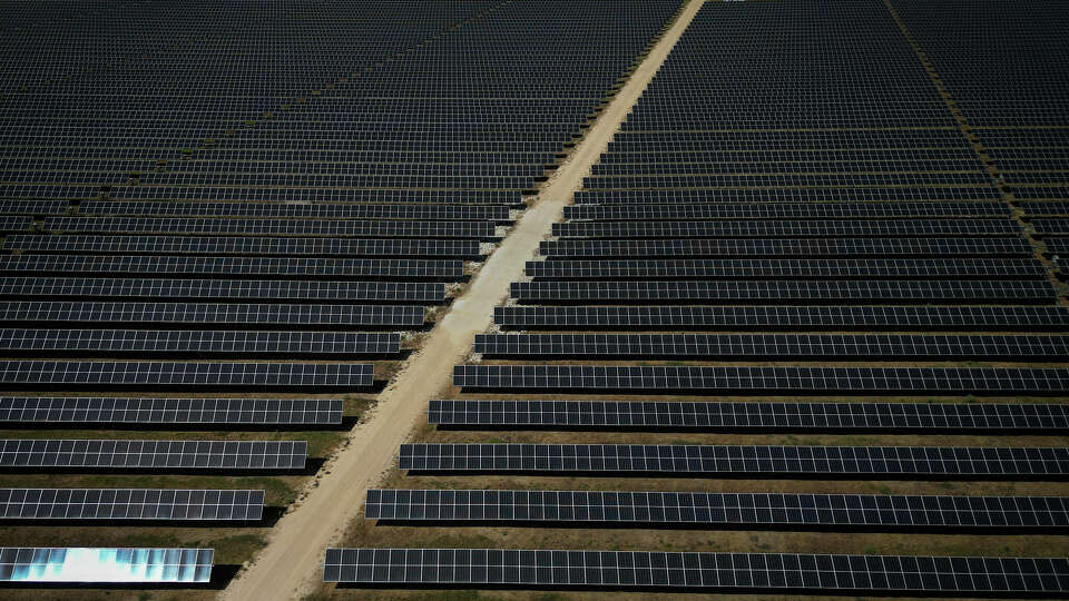 The sun beats down on Jake Dockins as he walks through a solar array in September at the Blue Jay solar and storage plant in Iola. Texas, which added more solar capacity in 2023 than any state ever has in a single year, is forecast to nearly double total capacity this decade, according to a new report.