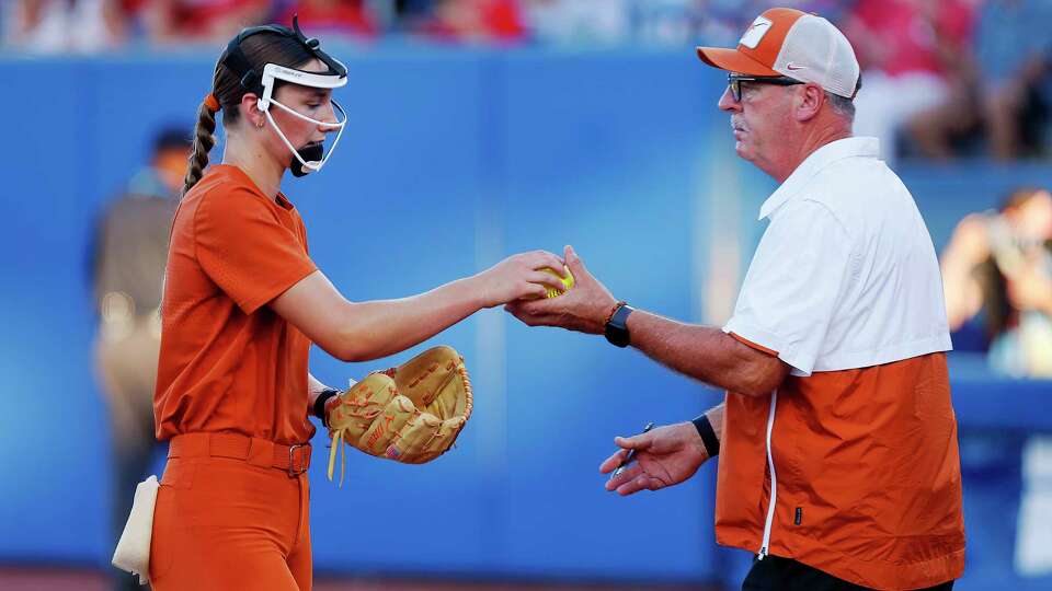 OKLAHOMA CITY, OK - JUNE 6: Pitcher Teagan Kavan #17 of the Texas Longhorns hands the ball to head coach Mike White as she is pulled from the game in the third inning against the Oklahoma Sooners during the Championship Finals of the 2024 NCAA Women's College World Series at OGE Energy Field at Devon Park on June 6, 2024 in Oklahoma City, Oklahoma. Kavan took the loss, giving up five hits and five runs. Oklahoma won 8-3.