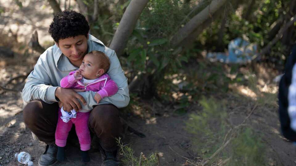 Sergio Franco, of Ecuador, holds his daughter as he waits to apply for asylum, Wednesday, June 5, 2024, near Dulzura, Calif. President Joe Biden on Tuesday unveiled plans to enact immediate significant restrictions on migrants seeking asylum at the U.S.-Mexico border as the White House tries to neutralize immigration as a political liability ahead of the November elections.