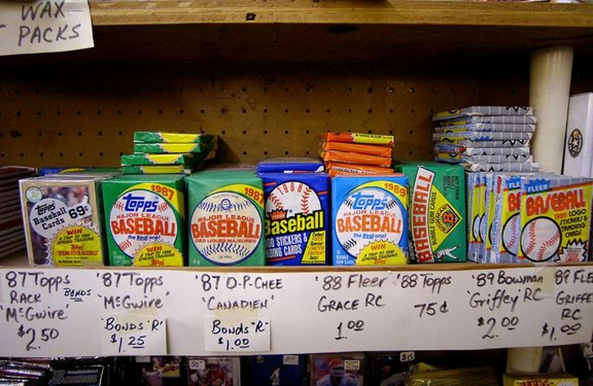 Richard Tyner, better known as "Coach" has been collecting and trading sports collectibles for 30 years. In his shop, located on S 11th street at the old K-Mart Flea Market/Bingo Hall, Tyner has just about everything including shelves of baseball card packs like this that still have the bubble gum. Dave Ryan/The Enterprise