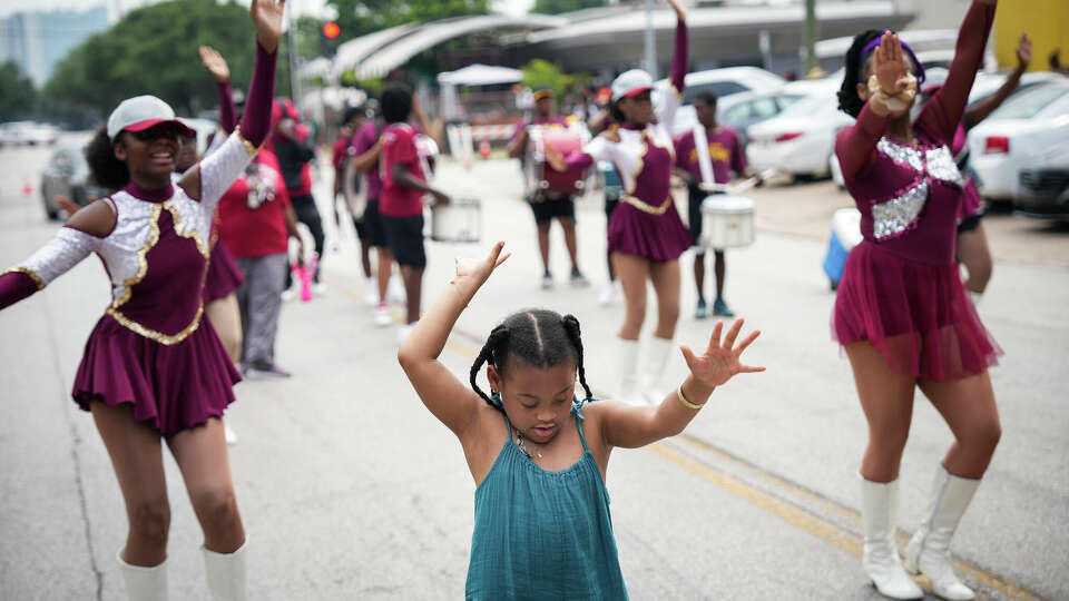 Zoe McGilbert, 7, center, performs with dancers from Lawson Academy after spontaneously joining a Juneteenth parade Saturday, June 17, 2023, in the Third Ward neighborhood in Houston.