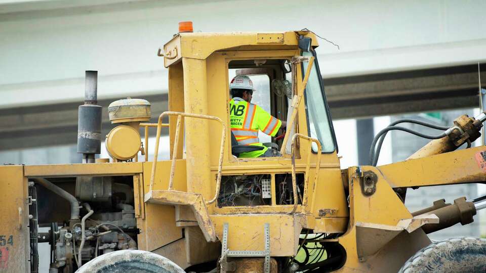 A backhoe loader moves material across the construction site near Interstate 69 on Monday, June 10, 2024 in Houston.