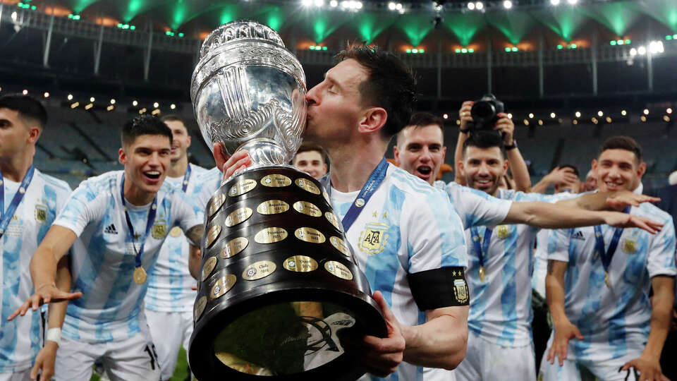 Argentina's Lionel Messi kisses the trophy after beating Brazil 1-0 in the Copa America final soccer match at Maracana stadium in Rio de Janeiro, Brazil, Saturday, July 10, 2021. Messi's road to a repeat could take him through Houston this summer.