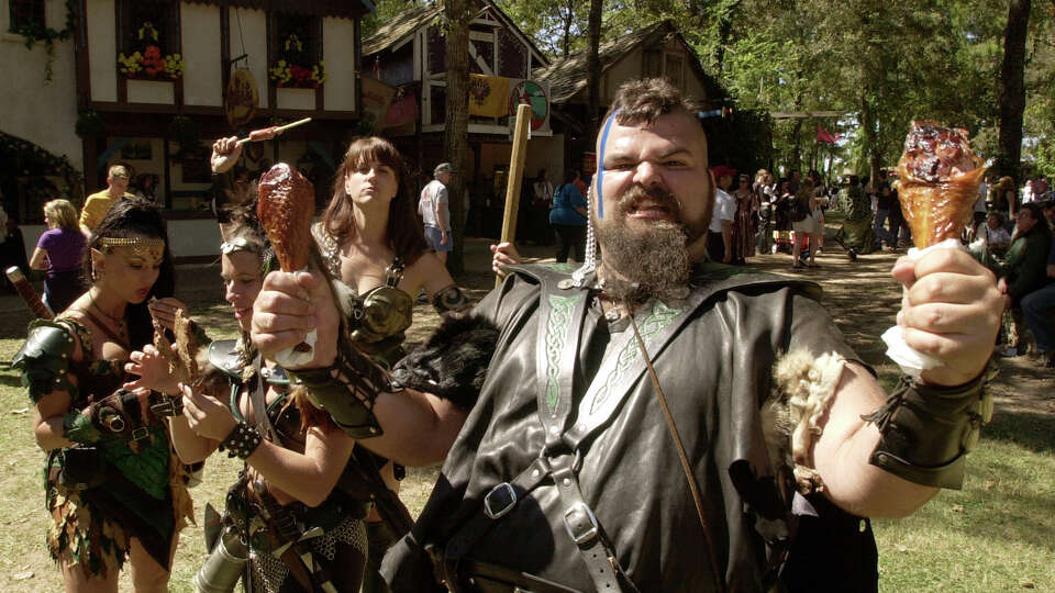 Barbarian Koolagh (Eric Castille), right holds up a pair of turkey legs as other barbarians, from left, Taarna (Sheilagh Gallagher, Kiva (Angela Lorio) and Xen (Kristin Daugherty) eat various meat on a stick available during the Texas Renaissance Festival Sunday, Oct. 7, 2001.