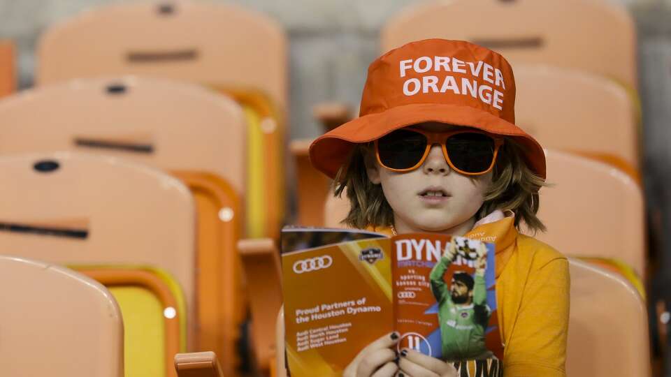 A Houston Dynamo fan reads the team program before taking on Sporting Kansas City for the MLS game at BBVA Compass Stadium Wednesday, Oct. 11, 2017, in Houston. ( Yi-Chin Lee / Houston Chronicle )