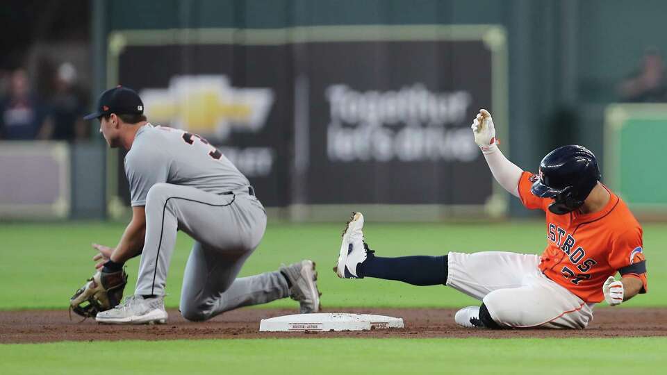 Houston Astros second base Jose Altuve (27) slides safely into second under Detroit Tigers second base Colt Keith (33) for a lead-off double at Minute Maid Park on Friday, June 14, 2024 in Houston.