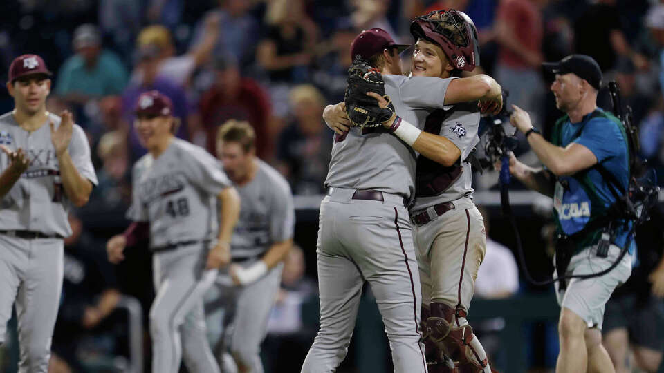 Texas A&M pitcher Josh Stewart (34) and catcher Jackson Appel (20) celebrate their 5-1 win after the final out of an NCAA College World Series baseball game against Kentucky on Monday, June 17, 2024, in Omaha, Neb. (AP Photo/Mike Buscher)