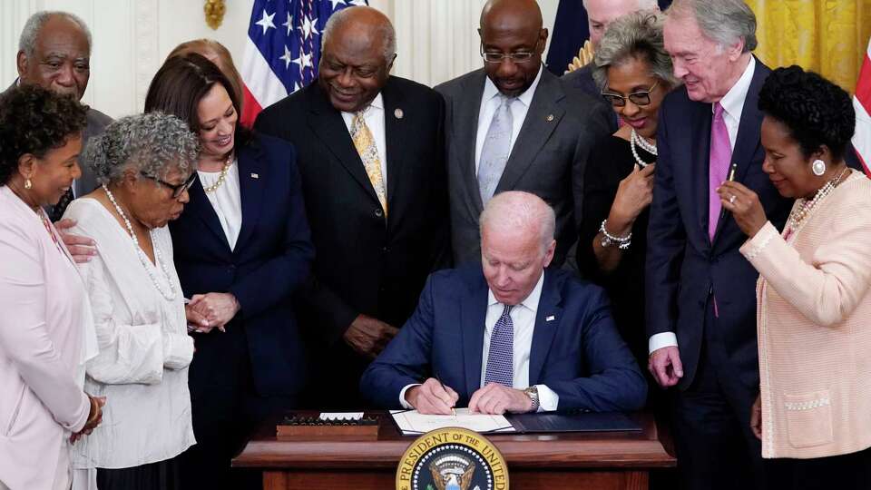 FILE - President Joe Biden signs the Juneteenth National Independence Day Act, in the East Room of the White House, Thursday, June 17, 2021, in Washington. From left, Rep. Barbara Lee, D-Calif, Rep. Danny Davis, D-Ill., Opal Lee, Sen. Tina Smith, D-Minn., obscured, Vice President Kamala Harris, House Majority Whip James Clyburn of S.C., Sen. Raphael Warnock, D-Ga., Sen. John Cornyn, R-Texas, Rep. Joyce Beatty, D-Ohio, Sen. Ed Markey, D-Mass., and Rep. Sheila Jackson Lee, D-Texas.