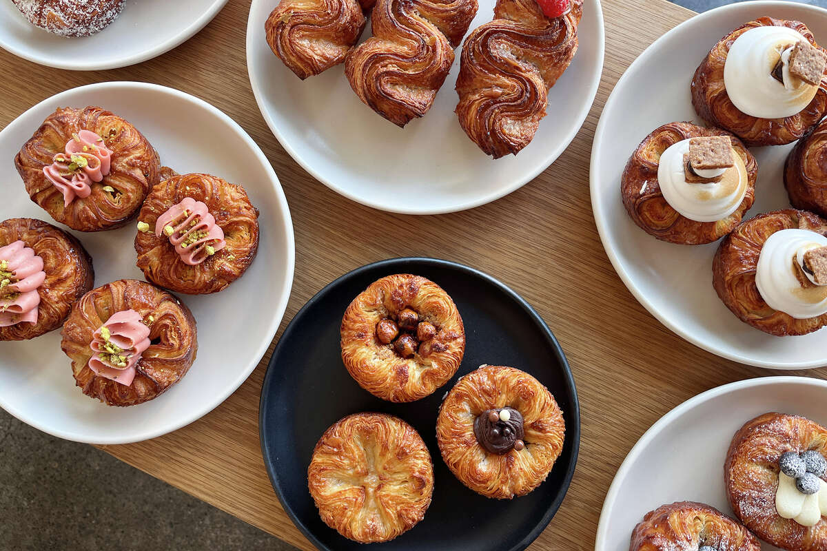 Clockwise from top left, coconut cream, squiggle, s’mores, blueberry lemon, traditional (plus hazelnut and chocolate) and strawberry pistachio kouign-amann at Starter Bakery in Oakland, Calif., on June 12, 2024.