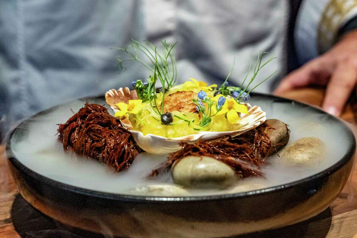 Owner and chef David Skinner holds an original dish he calls three sisters, beans, corn and squash, with scallops in the dinning room at Ishtia, Tuesday, June 18, 2024 one of numerous signature dishes inspired by native American culture, customs and cuisine on Harris Avenue in Kemah.