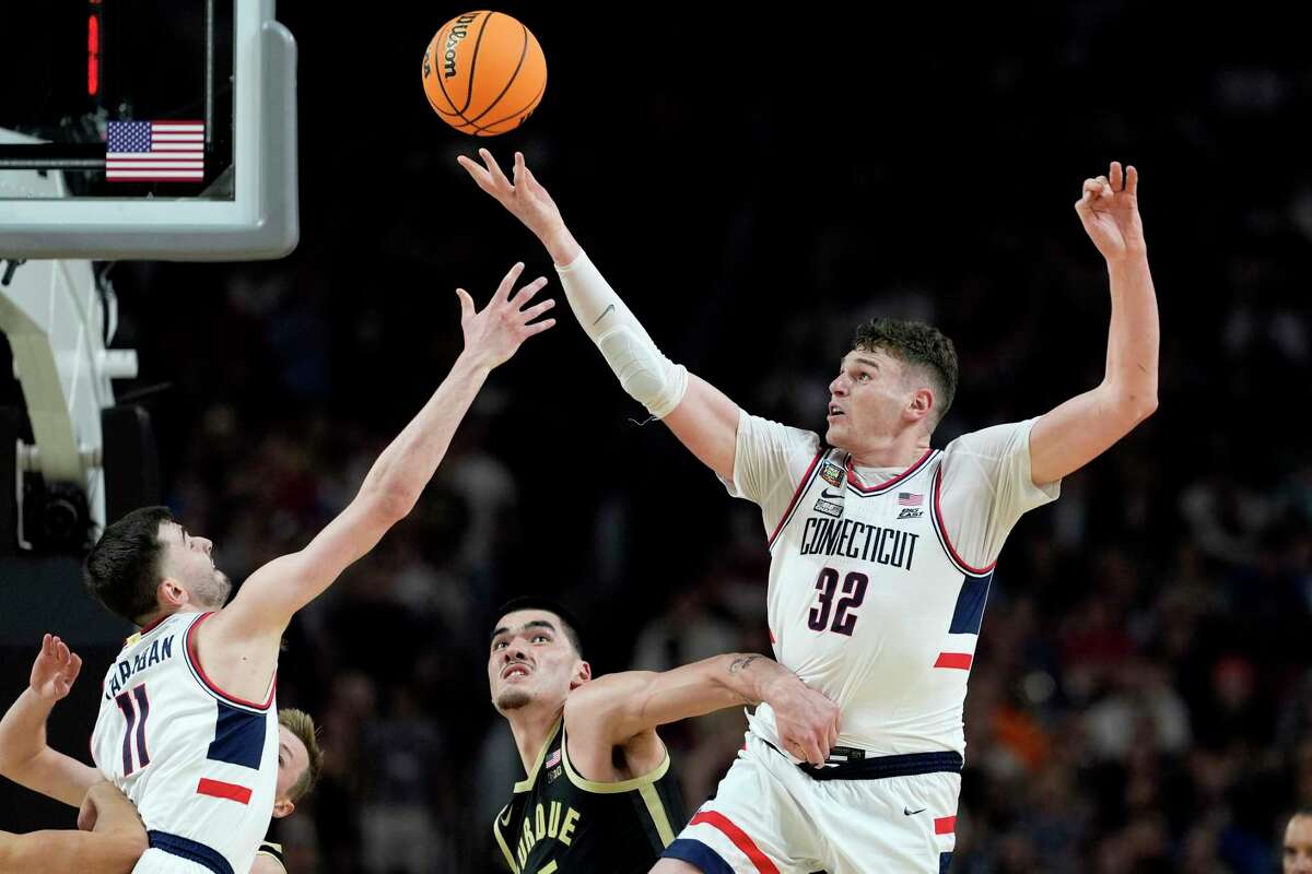 FILE - UConn center Donovan Clingan (32) reaches for the ball as Purdue center Zach Edey defends during the second half of the NCAA college Final Four championship basketball game, Monday, April 8, 2024, in Glendale, Ariz. Clingan is considered to be among the top prospects in this month's NBA draft. (AP Photo/Brynn Anderson, File)