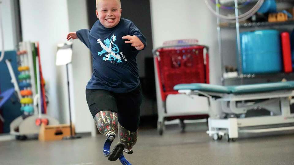 Zach Harrell runs around the gym while doing physical therapy at TIRR Memorial Hermann-The Woodlands on Wednesday, June 19, 2024 in The Woodlands. Harrell was diagnosed at birth with thrombocytopenia-absent radius syndrome, a rare condition affecting one in 100,000 or 200,000 individuals. One symptom is that he is missing the radius bone in both arms (meaning he does not have use of his thumb and his arms are shortened). He was also born without kneecaps and had to have both legs amputated above the knee. None of this holds him back, however. He has learned to run on his blade prosthetics, has participated in Little League, swim team and tried adaptive skiing, surfing and kayaking.