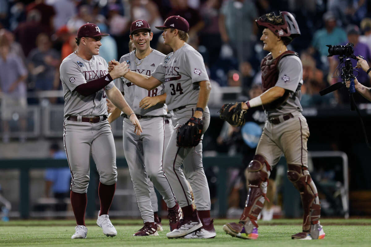 Texas A&M pitcher Josh Stewart (34) celebrates with teammates after the final out of an NCAA College World Series baseball game against Kentucky on Monday, June 17, 2024, in Omaha, Neb.