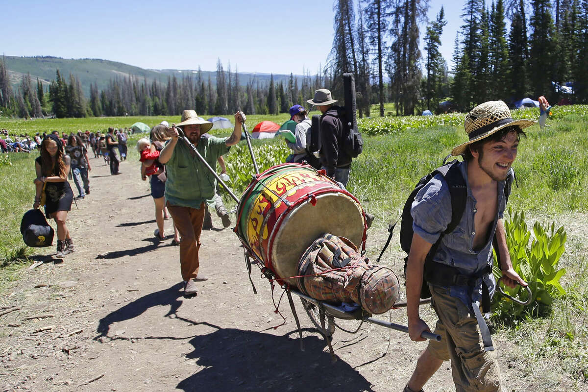 FILE: People walk along a trail in the Rainbow Family encampment in the Uinta National Forest, Utah. 