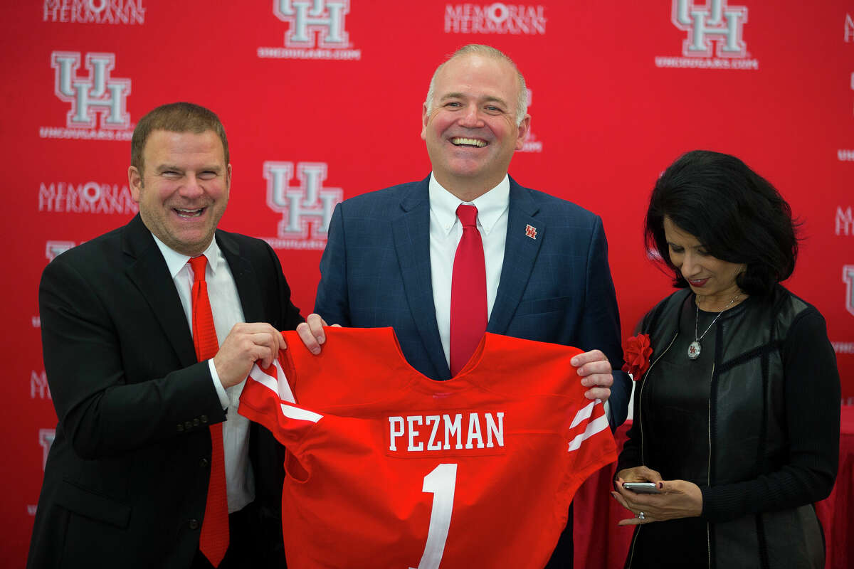 University of Houston board chairman Tilman Fertitta (left) and university chancellor Renu Khator (right) pose for photos with new athletic director Chris Pezman following an introductory press conference at TDECU Stadium, Tuesday, Dec. 12, 2017, in Houston. ( Mark Mulligan / Houston Chronicle )