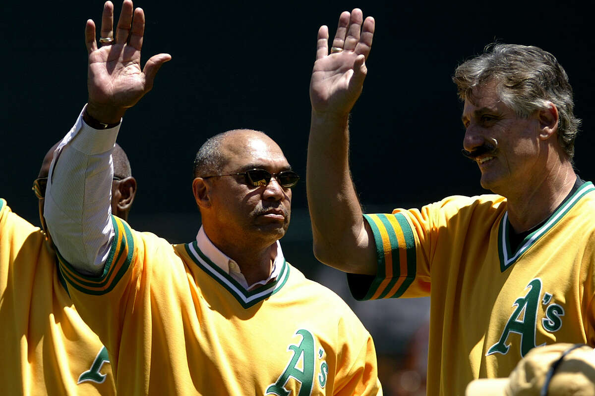 Former Oakland Athletics Vida Blue, left, Reggie Jackson, center, and Rollie Fingers wave to fans during a ceremony honoring the 1974 Oakland Athletics World Championship team before a game between the Athletics and the Chicago White Sox in Oakland, Calif. on Saturday, July 17, 2004.