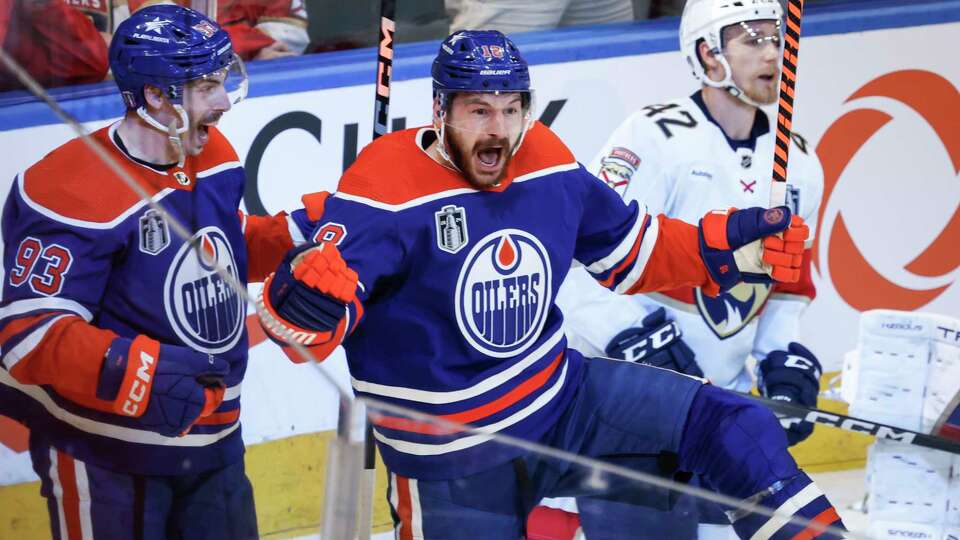 Edmonton Oilers' Zach Hyman (18) celebrates his goal against the Florida Panthers with Ryan Nugent-Hopkins (93) as Panthers' Gustav Forsling (42) skates past during the second period of Game 6 of the NHL hockey Stanley Cup Final, Friday, June 21, 2024, in Edmonton, Alberta. (Jeff McIntosh/The Canadian Press via AP)