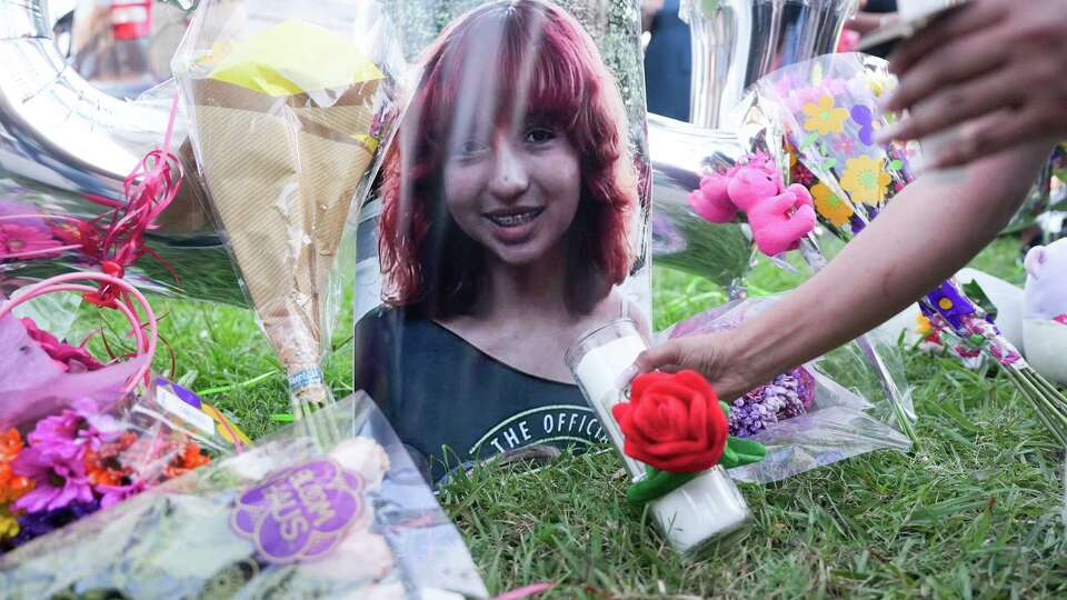 An attendee places a candle near a photo of 12-year-old Jocelyn Nungaray, during a candlelight vigil for her on Friday, June 21, 2024 in Houston.