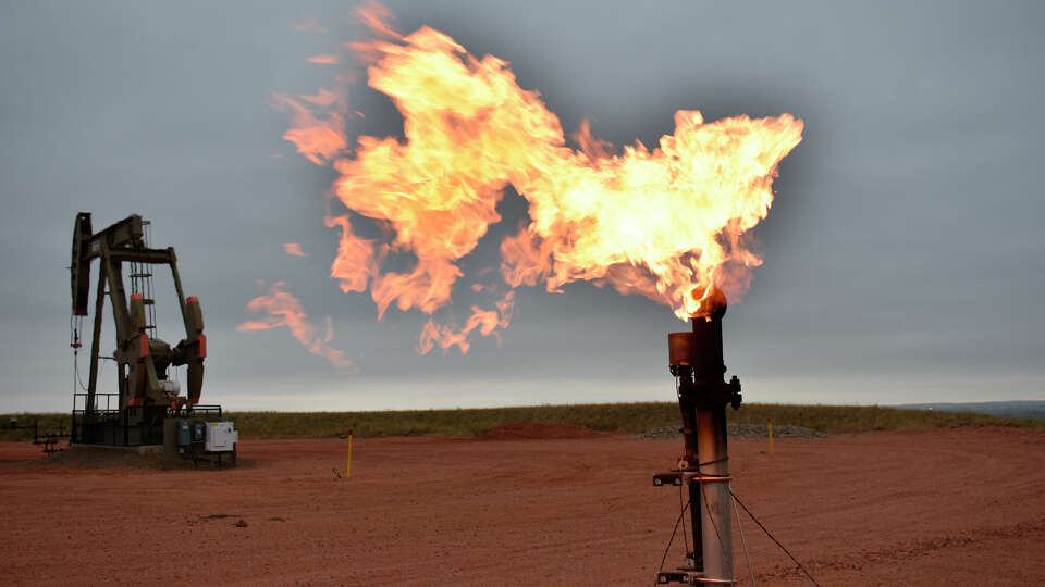 FILE - A flare burns natural gas at an oil well on Aug. 26, 2021, in Watford City, N.D. A new federal report released Friday, Oct. 29, 2021, says fossil fuel extraction from federal lands produced more than 1 billion tons (918 million metric tons) of greenhouse gases last year. (AP Photo/Matthew Brown, File)