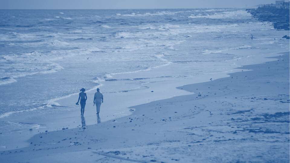 People walk down the beach near Jimmy's on the Pier, Wednesday, May 11, 2022, in Galveston.