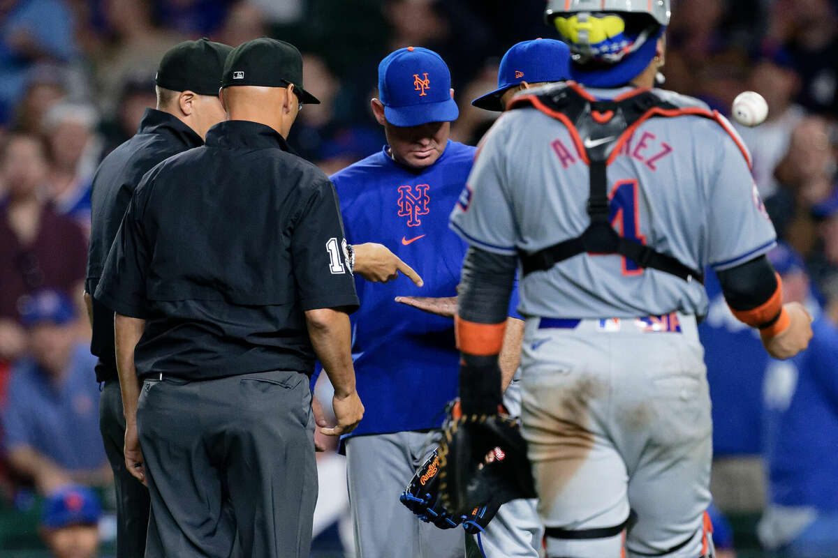  Umpires check the glove and hands of pitcher Edwin Diaz #39 of the New York Mets as Manager Carlos Mendoza #64 looks on during a game against the Chicago Cubs at Wrigley Field on June 23, 2024 in Chicago, Illinois. Diaz was ejected for having an illegal substance. 