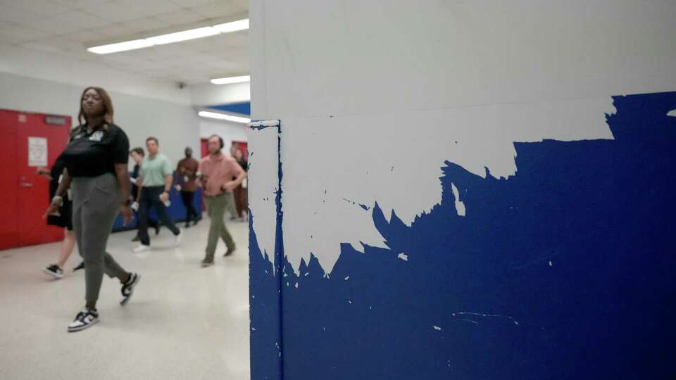 Peeling paint is shown on hallways walls as Monique Moody, principal, leads a tour at Revere Middle School, 10502 Briar Forest Dr., Tuesday, June 25, 2024, in Houston.